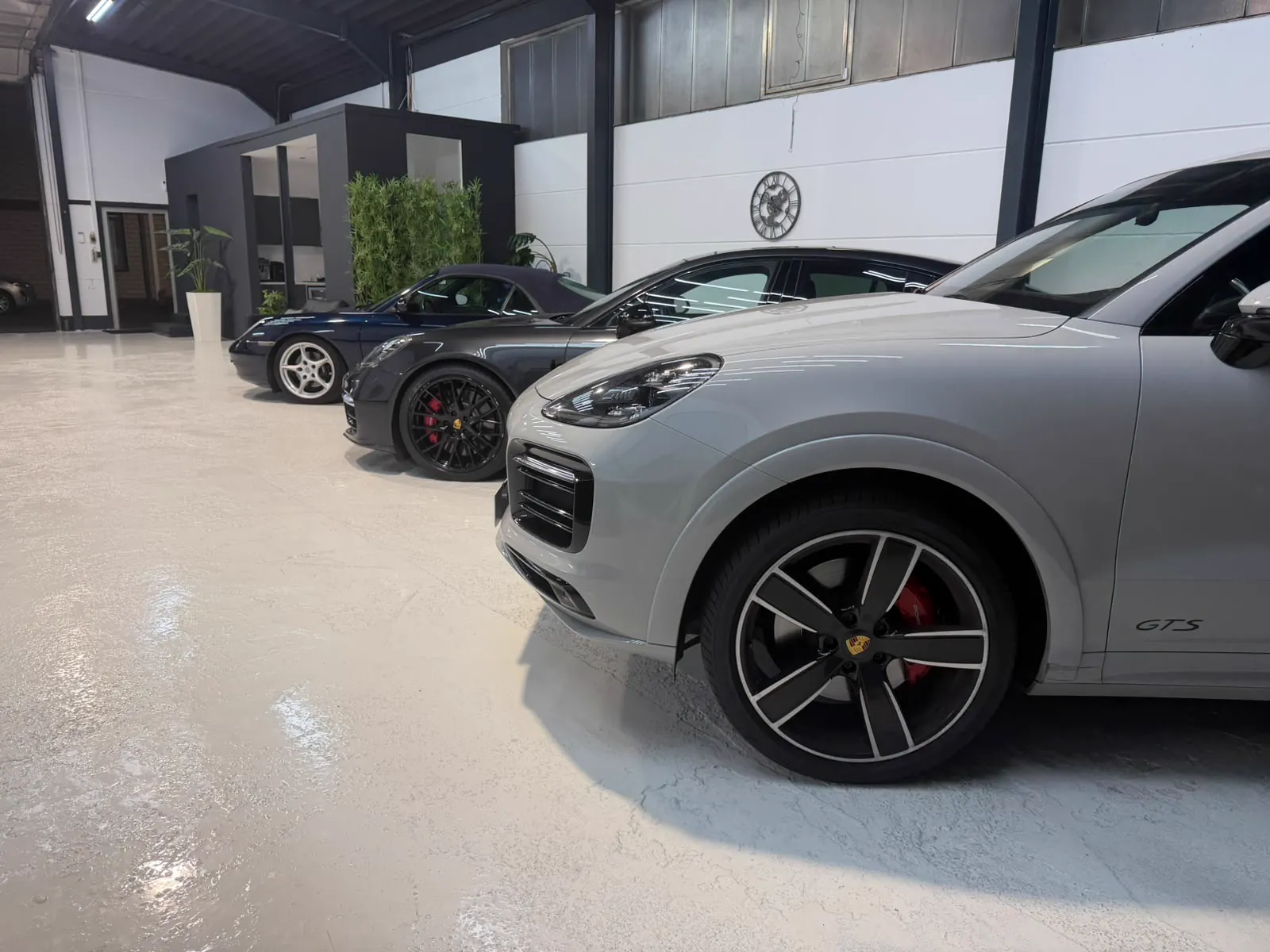 Porsche Cayenne neben weiteren Fahrzeugen in der Halle